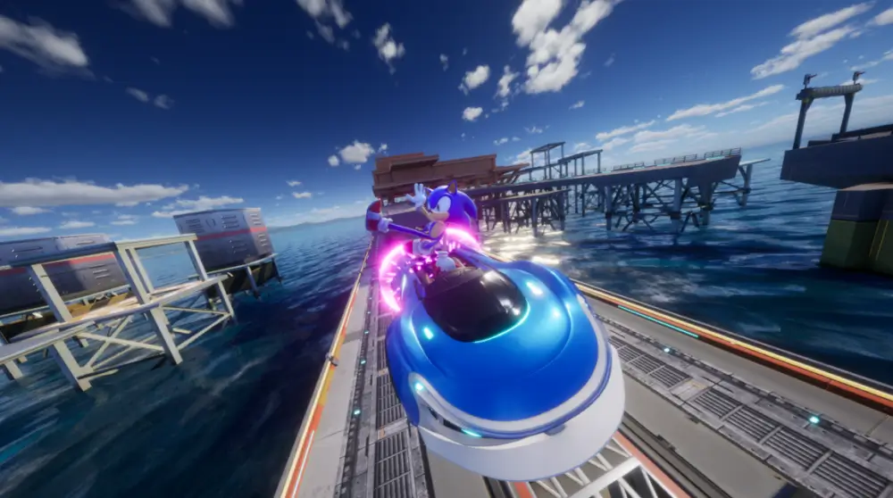 Sonic Racing: Crossworlds סוניק נוהג במכונית כחולה על גשר ומתחת יש ים גדול